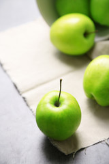 Green apples on wooden table with napkin, closeup