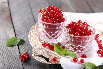 Fresh red currants in glasses on table close up