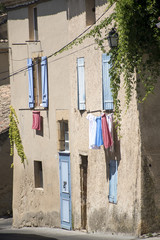 typical house in south France with blue shutters and drying laun