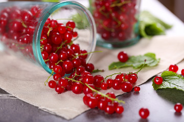 Ripe red currants in glass on table, closeup