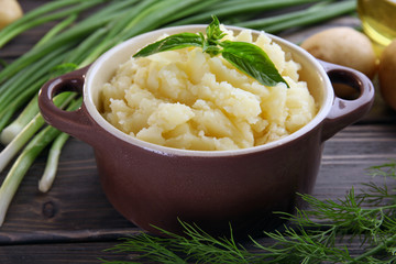 Mashed potatoes in bowl on wooden table, closeup