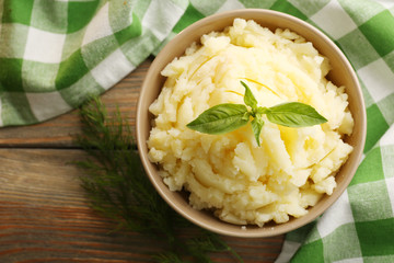 Mashed potatoes in bowl on wooden table, top view