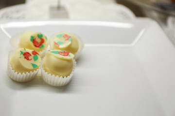 Delicious chocolate candies on plate close up