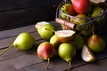 Ripe tasty pears in basket on table close up