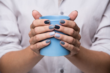 Female hands with blue cup