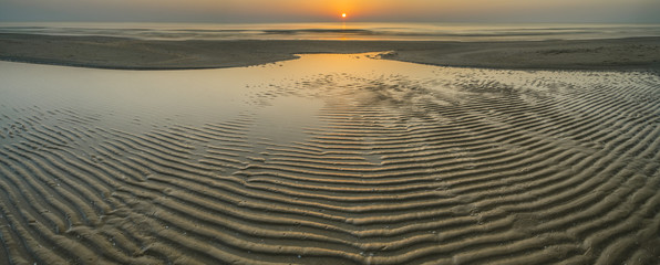 sunset and sand with low water in Italy