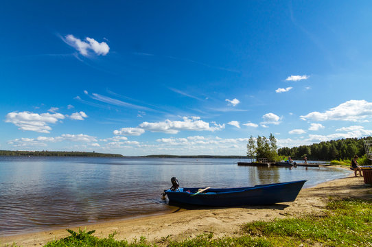 летний пейзаж с озером и моторной лодкой