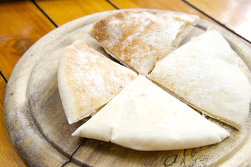 Slices of pita bread on wooden stand