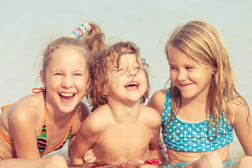 Three happy children  playing on the beach