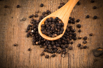 black pepper on wooden spoon