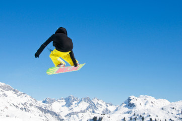 Snowboarder springt vor Bergpanorama