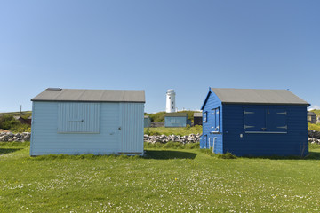 Lighthouse and beach huts at Portland Bill on Dorset coast