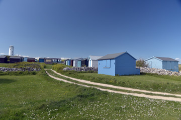 Fototapeta na wymiar Lighthouse and beach huts at Portland Bill on Dorset coast