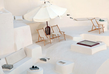 White terrace with deck chairs in caldera house, Santorini, Greece