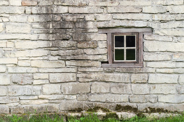 Old limestone wall with square wooden window
