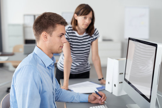 kollegen im büro schauen gemeinsam auf den computer