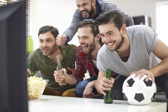 Group of best friends watching match on TV