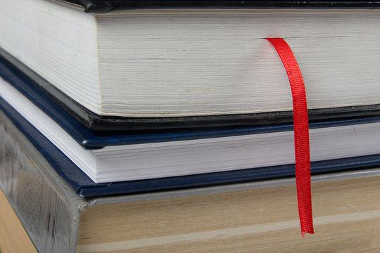 Stack of Books with red bookmark. Closeup shot