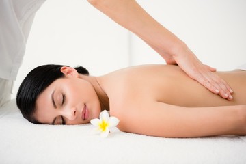 Fototapeta na wymiar Pretty brunette enjoying a massage with flower