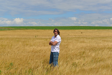 Naklejka na ściany i meble man stands on the rye field