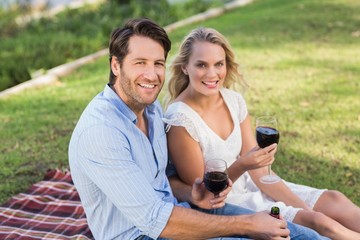 Cute couple on date holding red wine glasses