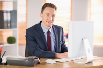 Fototapeta premium Stylish businessman working at his desk