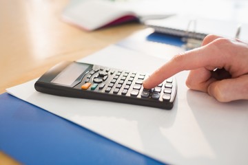 Businessman hands typing on calculator