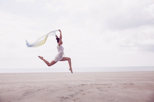 Stylish Woman Leaping With Scarf