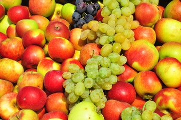 Autumn fruits at the market: grapes and apples.
