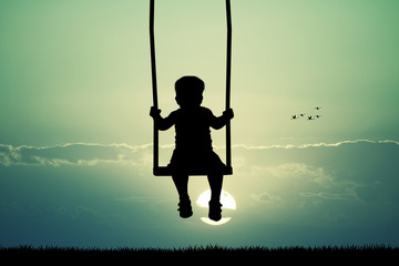 child on swing ilhouette at sunset