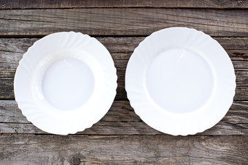 Empty white plates on wooden background