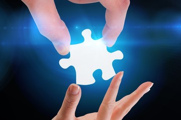 Composite image of hands holding jigsaw