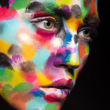 Girl with colored face painted. Art beauty image. 