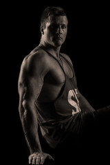 Fototapeta premium Strong athletic man on black background