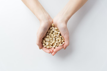close up of woman hands holding peeled peanuts