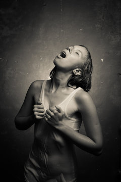 Wet girl in wet t-shirt on a gray background.