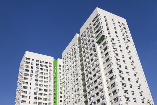Multistory new modern apartment building against the blue sky. Stylish living block of flats. Newly built block of flats