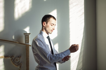 The man in the white shirt in the window dress cufflinks