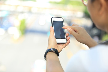 closeup of young woman skateboarder use smart phone in city