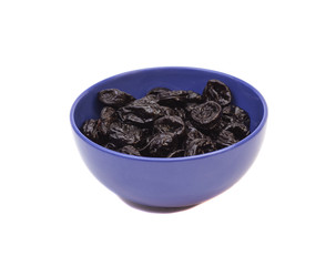 Prunes in blue bowl isolated