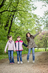Fototapeta premium Photo of three girls walking in the park