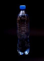 Small plastic water bottle on black background