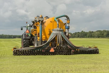 Deurstickers Injecting of liquid manure with tractor and yellow vulture sprea © TOF