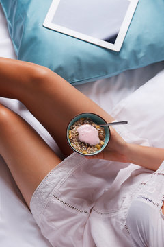 Woman eating healthy breakfast in the bed
