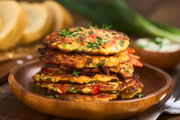 Vegetable and egg fritter made of zucchini, red bell pepper, eggs, green onions and thyme (Selective Focus, Focus on the front of the thyme sprig on the top of the fritters)