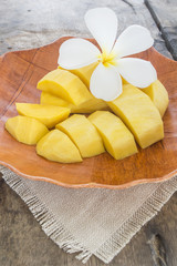 fresh mango fruit in white plate on wooden table