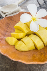 fresh mango fruit in white plate on wooden table