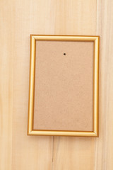 Fototapeta premium Empty golden picture frame on wooden background