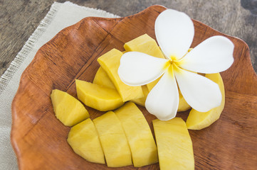 fresh mango fruit in white plate on wooden table