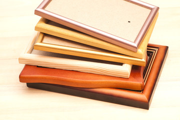 Stack of picture frames isolated on a wooden background